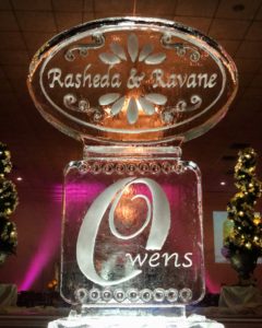 ice sculpture with names of the bride and groom (Rasheda & Ravane) in a detailed oval, placed atop a rectangular foundation piece with their surname (Owens)