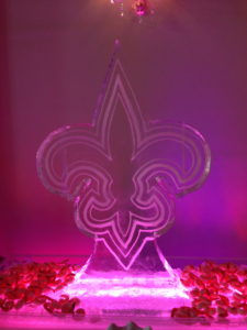 a New Orleans Saints fleur de lis ice sculpture with pink lighting