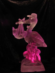 a stork ice sculpture with pink lighting by ice drago ice sculptures