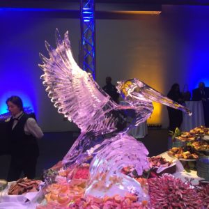 a flying pelican ice sculpture in a large seafood display