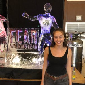 Alycia Debnam-Carey stands in front of zombie ice sculptures and the Fear the Walking Dead logo