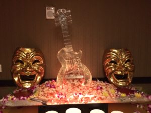 shrimp flows out of guitar ice sculpture in this seafood display