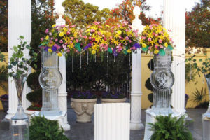 elaborate arbor combining flowers and ice sculpture supports for a wedding ceremony at Champagne Palace in Harahan