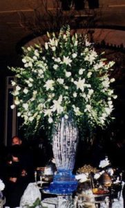 ionic column ice vase with a very large floral arrangement in the Blue Room at the Fairmont Hotel New Orleans. By ice dragon ice sculptures
