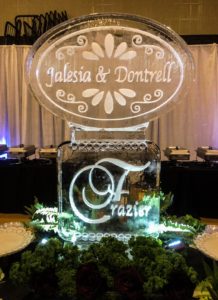 ice sculpture with names of the bride and groom (Jalesia & Dontrell) in a detailed oval, placed atop a rectangular foundation piece with their surname (Frazier)