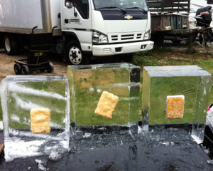 3 ice clear blocks with frozen fish patties inside, on set for a Popeye's commercial