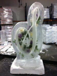 a script "S" ice sculpture with flowers frozen inside, sitting in the freezer. By ice dragon ice sculptures