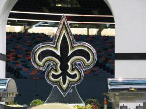 a black on gold Saints fleur de lis for an event on the field at the Superdome