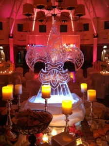 scrollwork fleur de lis ice carving surrounded by candles