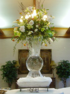 a simple ice vase with a large floral display on top