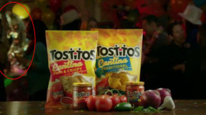 2 bags of Tostitos in a commercial, with a barely visible dolphin ice sculpture in the background
