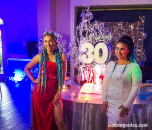 birthday girls flank this fire and ice drink luge with a big "30"