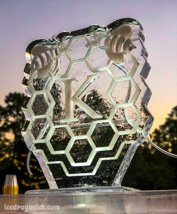 honeycomb ice luge with bees and a K initial at an outdoor wedding