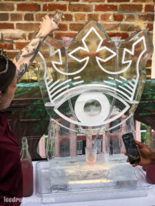 woman pouring a drink through a McQueen and the Violet Fog logo ice luge at Broussard's in the French Quarter